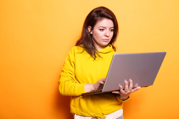 Female freelancer utilizing modern technology by using digital laptop. Portrait of focused woman...
