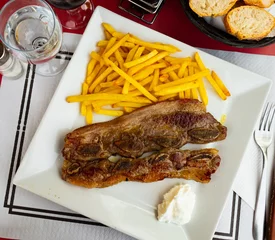 Outdoor kussens Spanish cuisine churrasco de ternera, spare ribs with potatoes on a white ceramic plate © JackF
