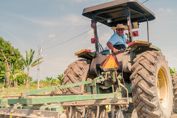 Farmer prepares the land for planting using a tractor.
