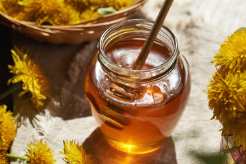 Two jars of dandelion honey with fresh dandelion flowers