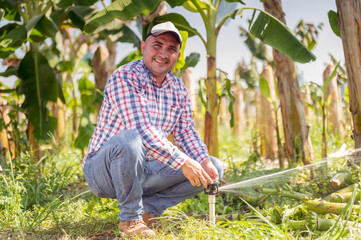 Portrait of farmer watering his banana plants.