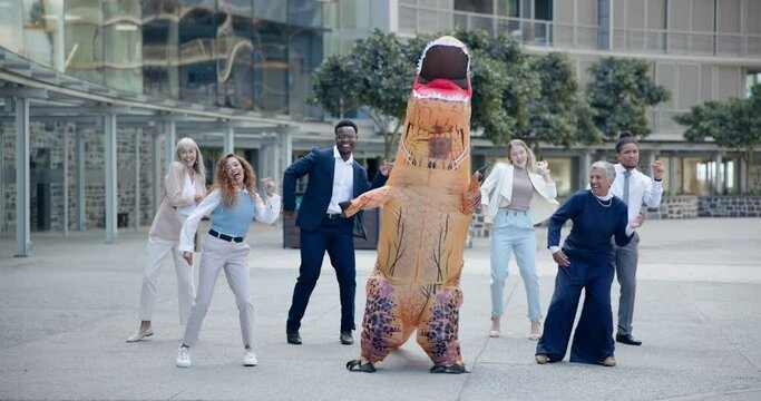 Business, people and dance outdoor in costume of inflatable dinosaur with fun and happiness at office. Funny, group and crazy team building at workplace with excited energy or comedy character