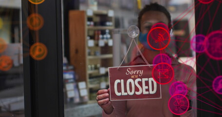 Caucasian business partner holding Sorry We're Closed sign, standing inside