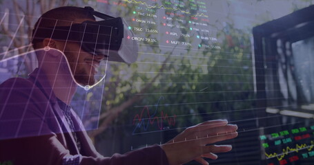 Biracial young man wearing virtual reality headset, interacting with digital data