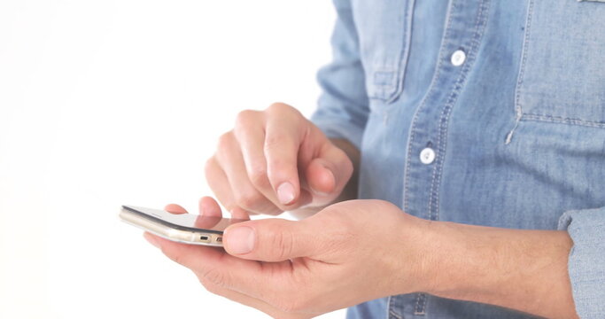 A person wearing blue shirt holding and typing on a smartphone