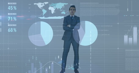 Caucasian male in suit stands before digital graphs