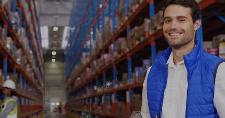 Caucasian male coworker wearing blue vest standing in a warehouse