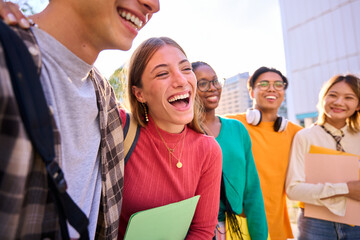 Laughing Caucasian female student with multiracial group of classmates posing hugging together for photo. Generation z friends smiling and having fun holding backpacks outdoor university campus - obrazy, fototapety, plakaty