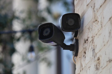 Closeup shot of outdoor security cameras on a stone wall exterior