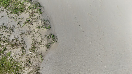 Aerial photo of amazingly beautiful sea view with blue water and white foamy waves on the sand.