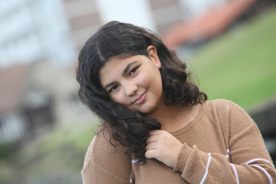 portrait of a smiling latin teenage girl with park background