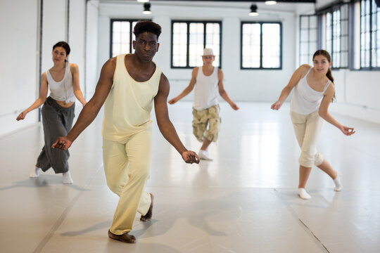 Group of dancers training twist dance moves in ball room