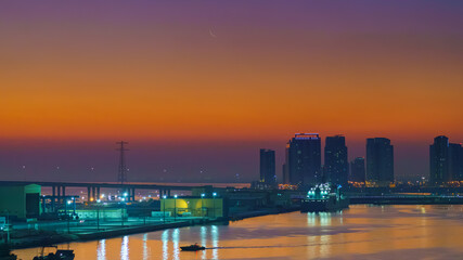 Fototapeta na wymiar Panoramic view of skyscrapers cityscape with illuminations and street lights on, at sunset, evening, Abu Dhabi, United Arab Emirates 