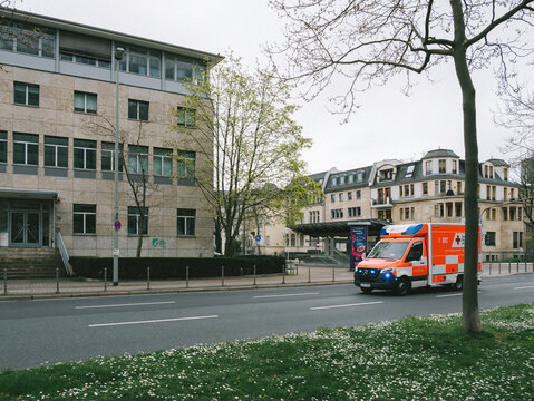 Frankfurt, Germany - Mar 31, 2024: A red Mercedes-Benz 112 emergency van speeds along a street in Frankfurt, Germany.