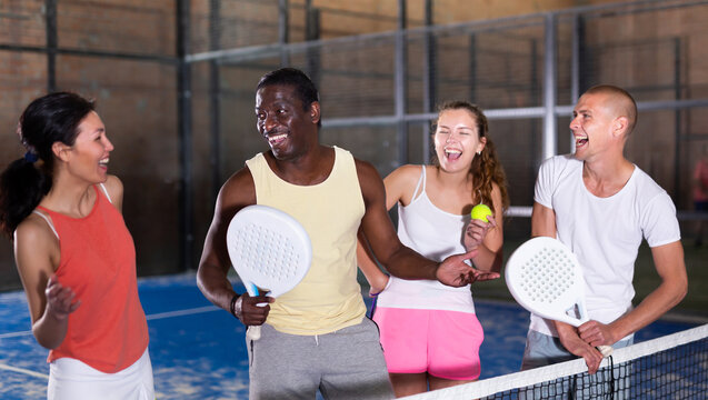 Group portrait of team of padel players standing at tennis court at fitness health club