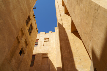 Doha, Qatar - Jan 14 2024, Bottom-up view of the narrow courtyard of the well, the blue sky is...