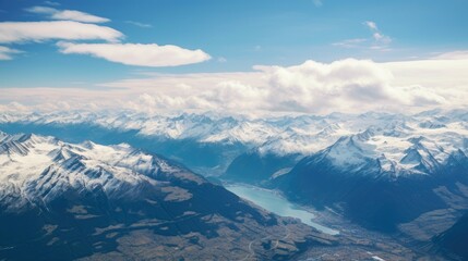 Obraz premium This is an aerial shot of the Swiss Alps. The snow-capped mountains are stunning, and the blue sky is dotted with clouds.