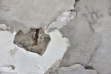  concrete wall crack and exposed the rusty steel bar frame. old concrete wall structure with...