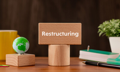 There is wood block with the word Restructuring. It is as an eye-catching image.
