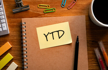 There is sticky note with the word YTD. It is an abbreviation for Year to date as eye-catching image.