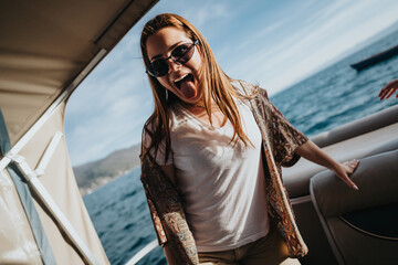 A happy girl expresses joy as she stands on a boat, basking in the warmth of a sunlit day at sea.