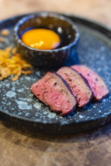Close-up of Beef tongue meat on plate and egg yolk served as Fine dining in Restaurant.