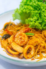 Closeup Spaghetti Tom Yum Seafood in white plate in a restaurant