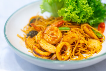 Closeup Spaghetti Tom Yum Seafood in white plate in a restaurant