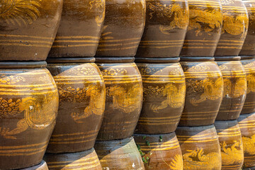 Rows of glazed water containers with a dragon pattern