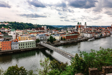 Fototapeta na wymiar Panoramic view of Passau. Top view of suspension bridge. Aerial skyline of old town with beautiful reflection in Danube river, Bavaria, Germany.