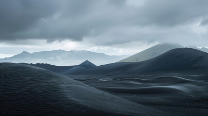 Fototapeta na wymiar Desolate black sand desert landscape with mountains under a cloudy sky