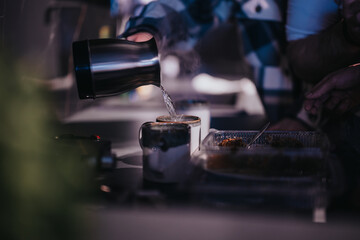 A close-up shot capturing a pleasant moment among friends sharing hot beverages and food on a laid back night indoors.