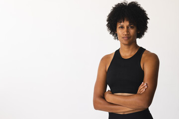 Biracial female yoga instructor standing in studio with arms crossed, looking serious, copy space - 788839809