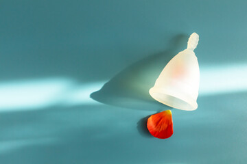 Mockup Menstrual Cup And Red Flower Petal On Blue Backdrop, Background with Shadow, Copy Space,...