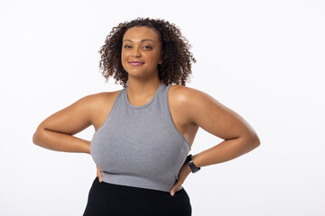 Biracial young female plus size model with hands on hips, standing confidently on white background - 788840023