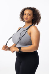A biracial young female plus size model holding a jump rope on a white background - 788840027