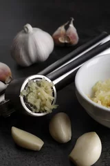 Fotobehang Garlic press, cloves and mince on grey table, closeup © New Africa