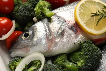Fotobehang Raw fish with vegetables and lemon in baking dish, closeup © New Africa