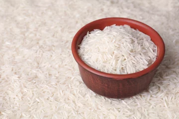 Schilderijen op glas Raw basmati rice and bowl as background, closeup. Space for text © New Africa