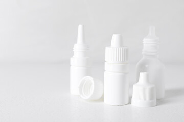Bottles of medical drops on white background, space for text