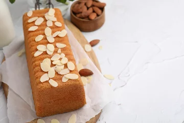 Fotobehang Cake with fresh almond flakes and nuts on white textured table, closeup. Space for text © New Africa