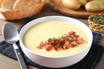 Gordijnen Tasty potato soup with bacon and rosemary in bowl served on wooden table © New Africa