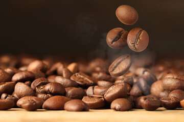 Roasted coffee beans falling on table, closeup