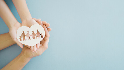 Hands holding multi generational family in heart shape paper, family wellness, health insurance...