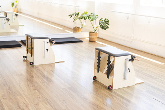 Two Pilates reformer machines are ready for use in bright studio, copy space