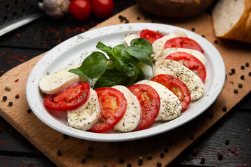mozzarella, basil and tomatoes on wooden background