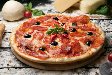 pizza with salami, cheese, mushrooms and olives on the wooden board