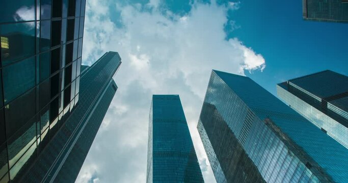 The city's skyscrapers soar high into the clouds as they float past timelapse