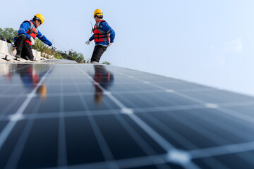 Photovoltaic engineers work on floating photovoltaics. workers Inspect and repair the solar panel equipment floating on water. Engineer working setup Floating solar panels Platform system on the lake.