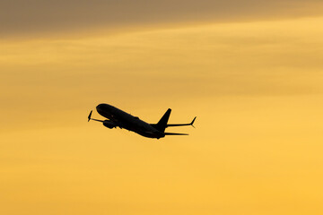 Climbing through the sunset. Large twin engine airliner departs for wider skies and a new...